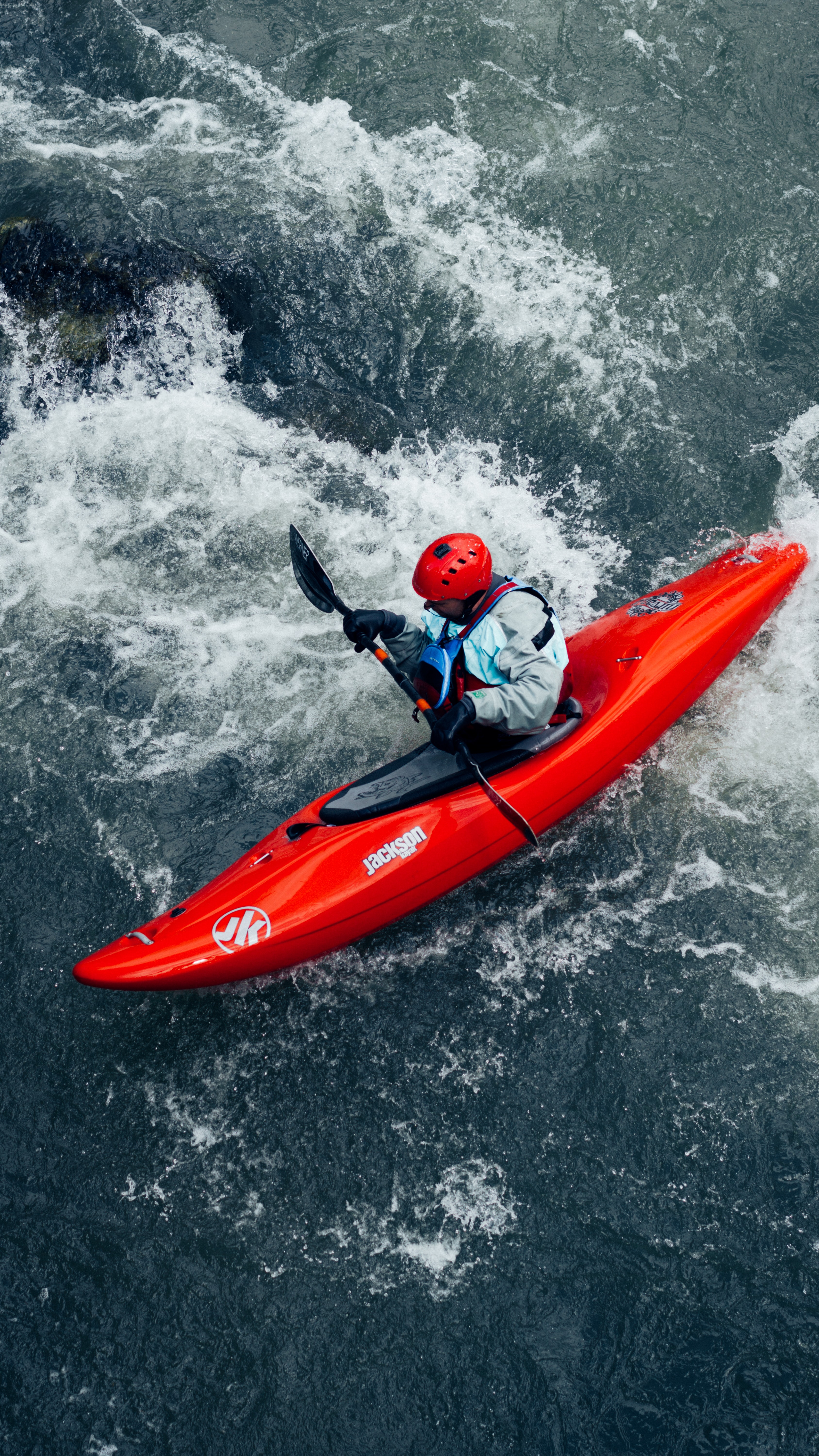 photo of kayaker with helmet in rough water